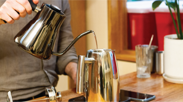 Pouring coffee into a coffee plunger using gooseneck kettle and Rumble coffee