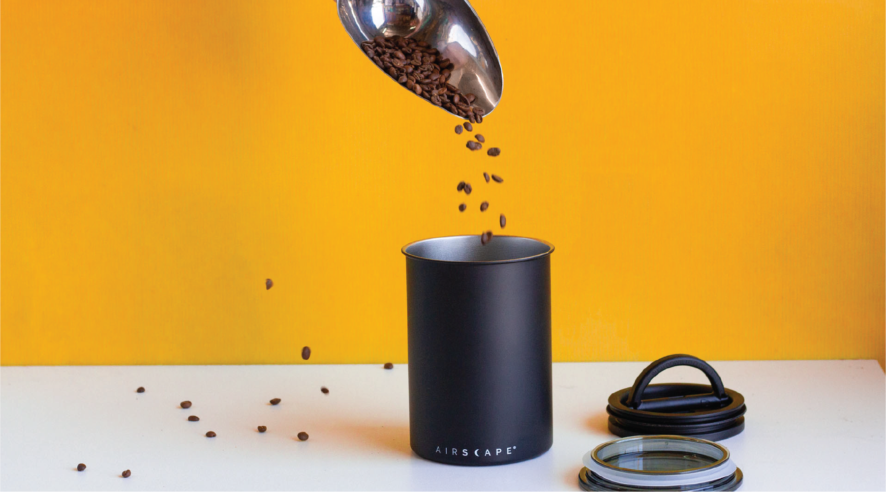 Pouring coffee beans into a coffee storage canister