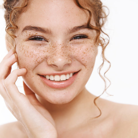 Smiling model with freckles on white background