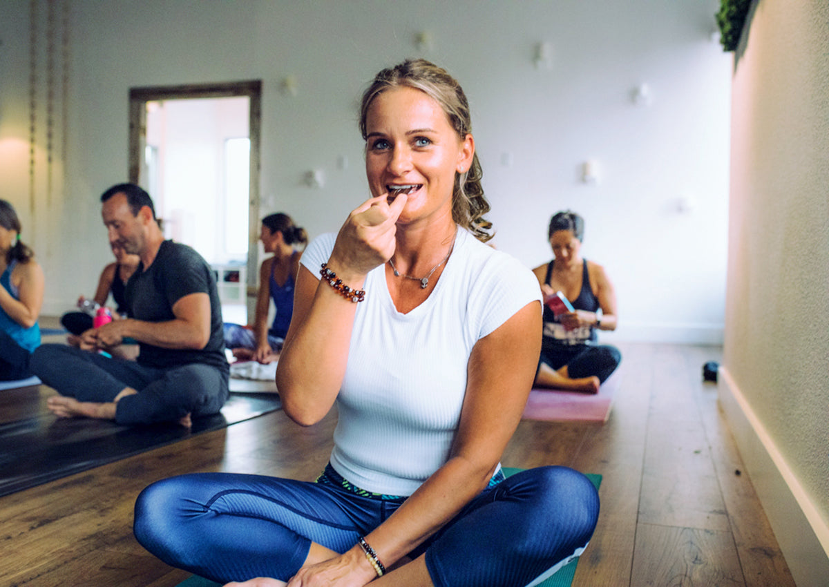 Lady on Yoga Mat Enjoying Pascha Dark Chocolate