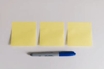 Scrum backlog with yellow sticky notes and a blue pen