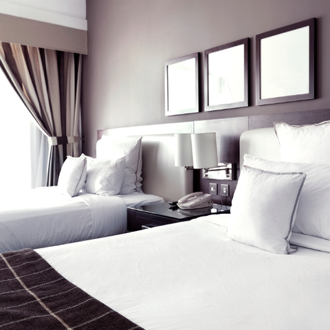 Two hotel beds topped with white linens