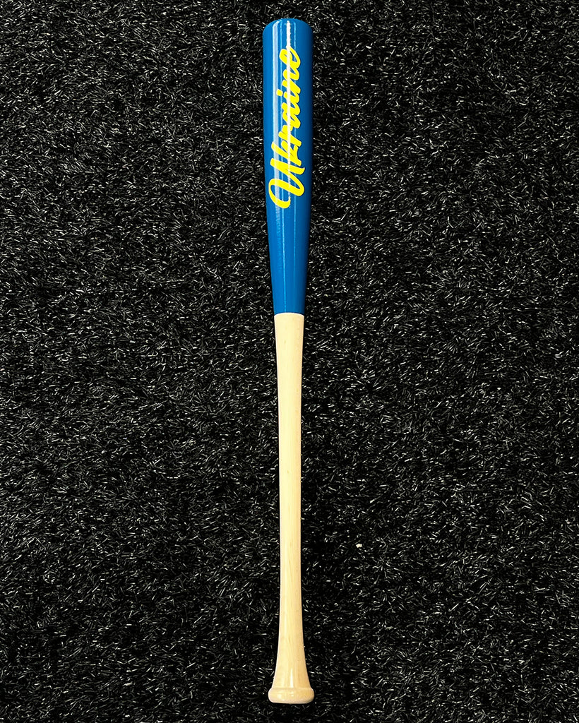 The back of bat #1, with a natural handle, royal blue barrel with Ukraine painted in yellow script.