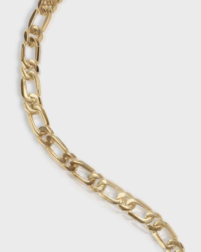 close up of figaro bracelet in solid 14k yellow gold