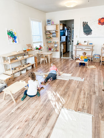 Kids work independently in a home classroom with 2 Luce shelves full of supplies