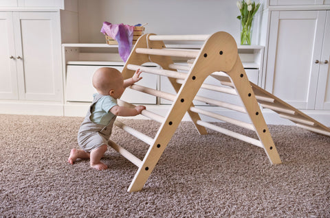 Baby using a climbing triangle