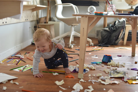 child crawling on messy floor