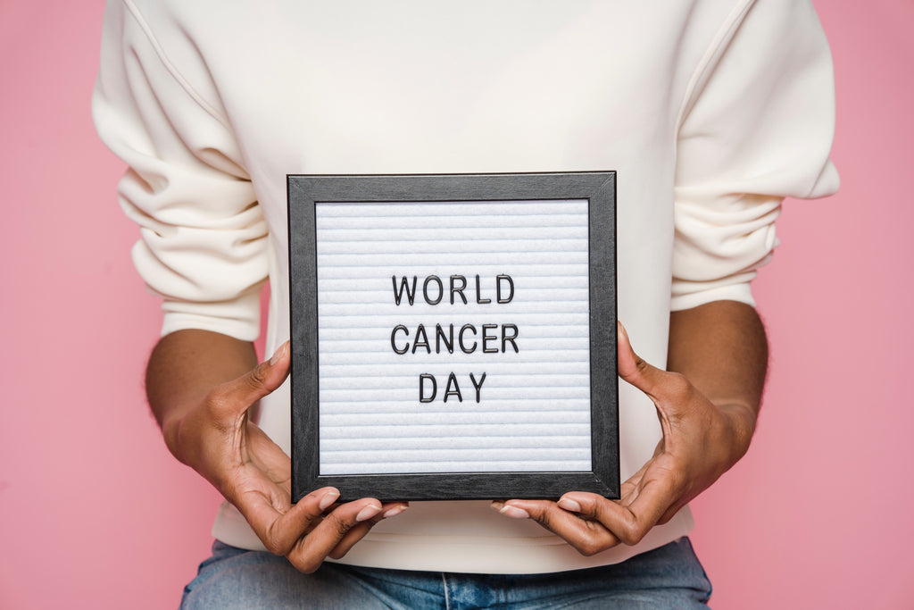 Image of woman holding a sign that reads "World Cancer Day"