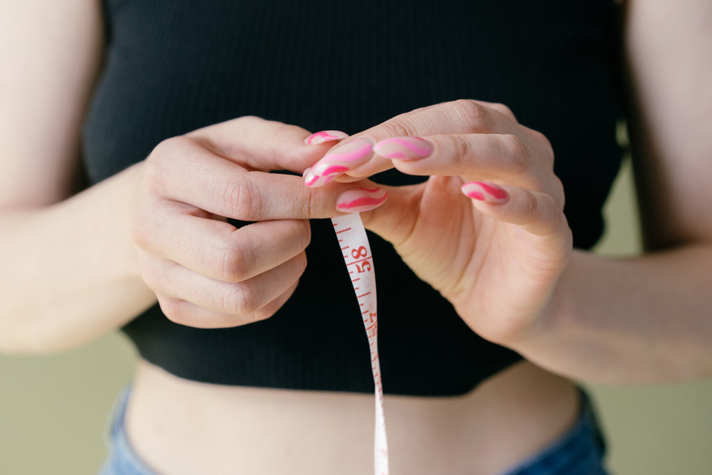 Image of woman's hands holding a tape measure