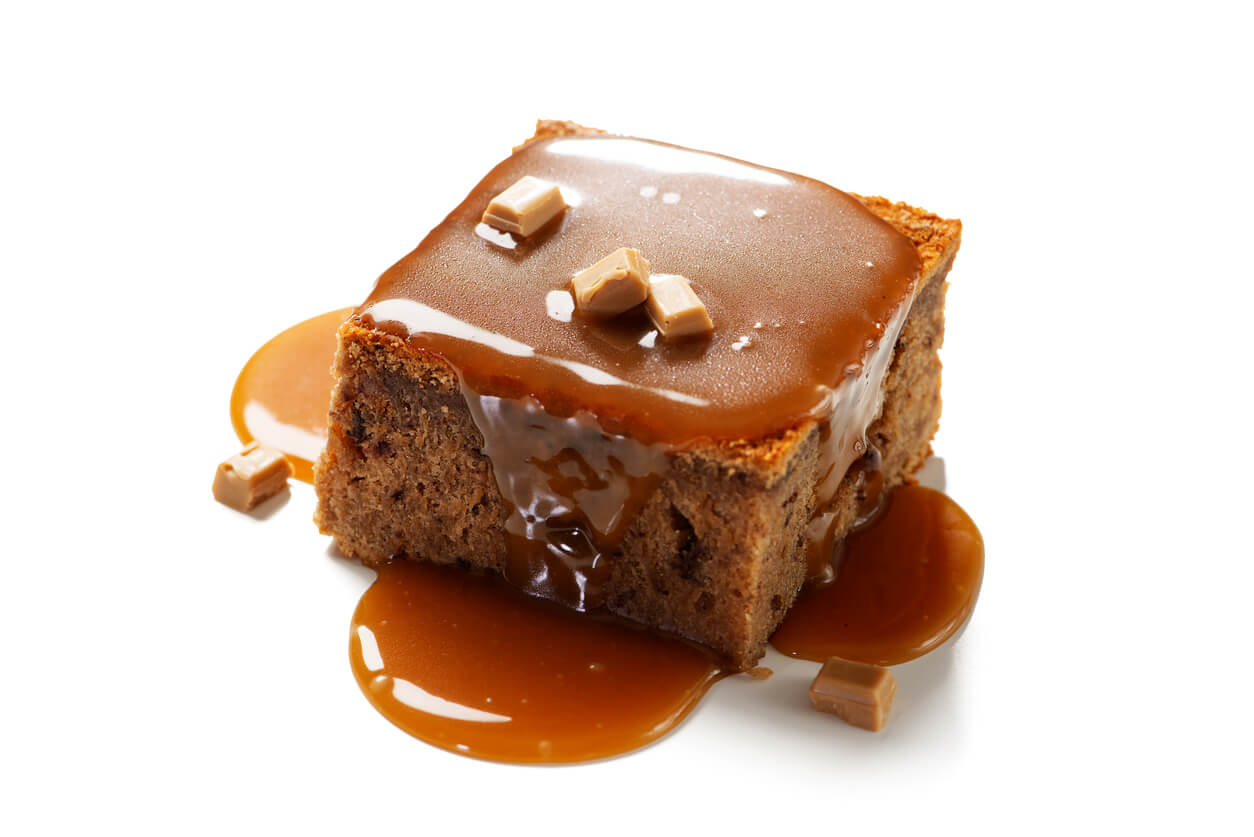 An image of a brownie topped with a caramel sauce and caramel chunks.