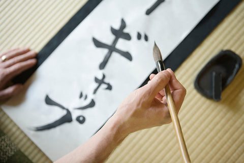 man writing japanese script