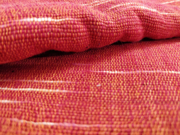 Uneven Space Dyed Red-Orange Khadi fabric by Cotton Rack also known as Jharna or Upkar Shirting in India