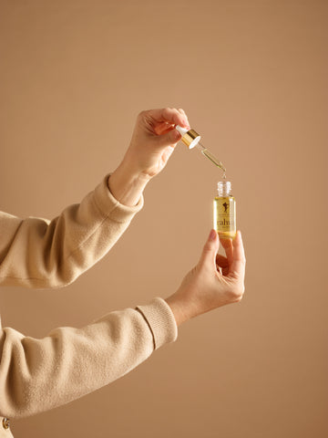 Woman holding opened rahua elixir bottle