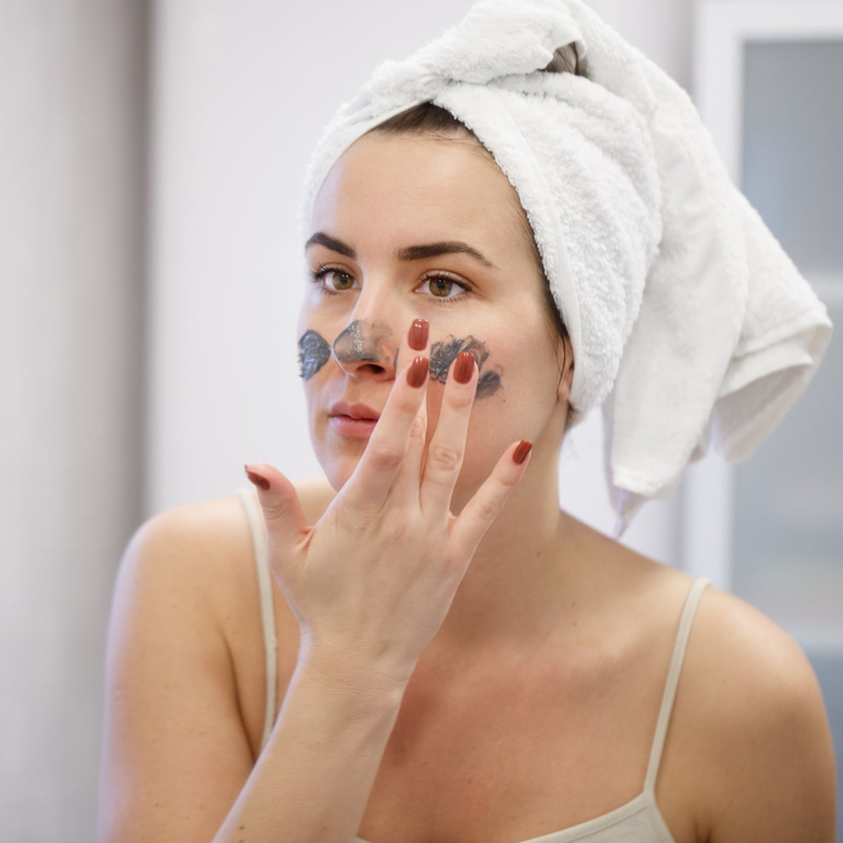 Mujer aplicando exfoliante de carbón