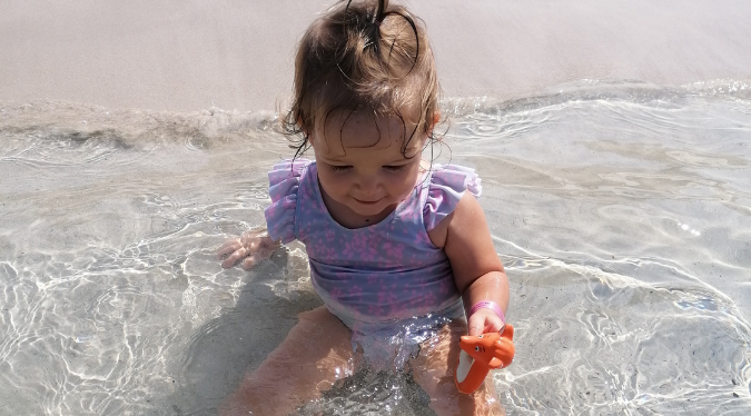 Baby playing with mini Mizzie in the water