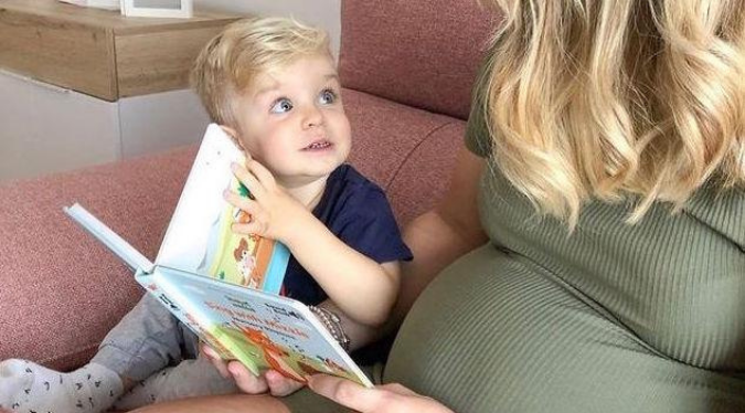 Baby is listening to mom while she is reading a Mizzie's book