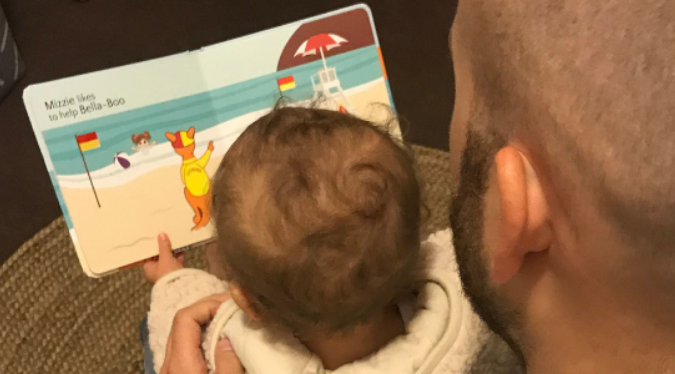 Dad reading to his baby