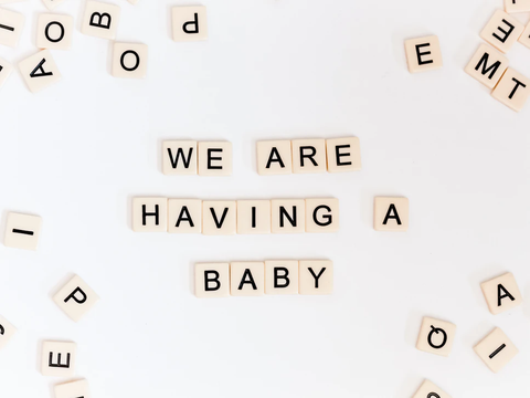 Letter tiles saying We Are Having A Baby