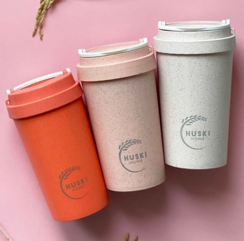 Reusable travel mugs on pink background