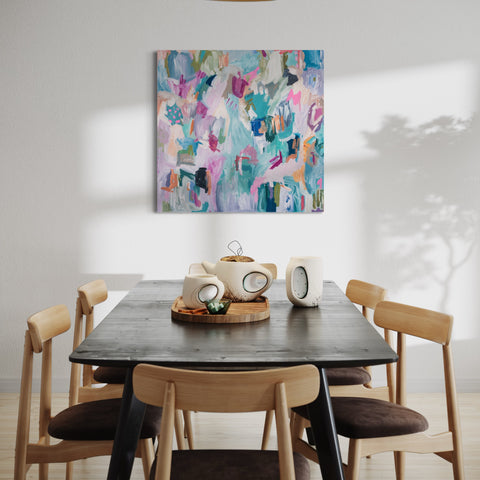 pastel colorful acrylic abstract art hung on wall behind dining table. minimalist and neutral design and decor.