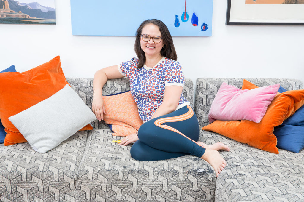 Tracy at home on the sofa with artwork