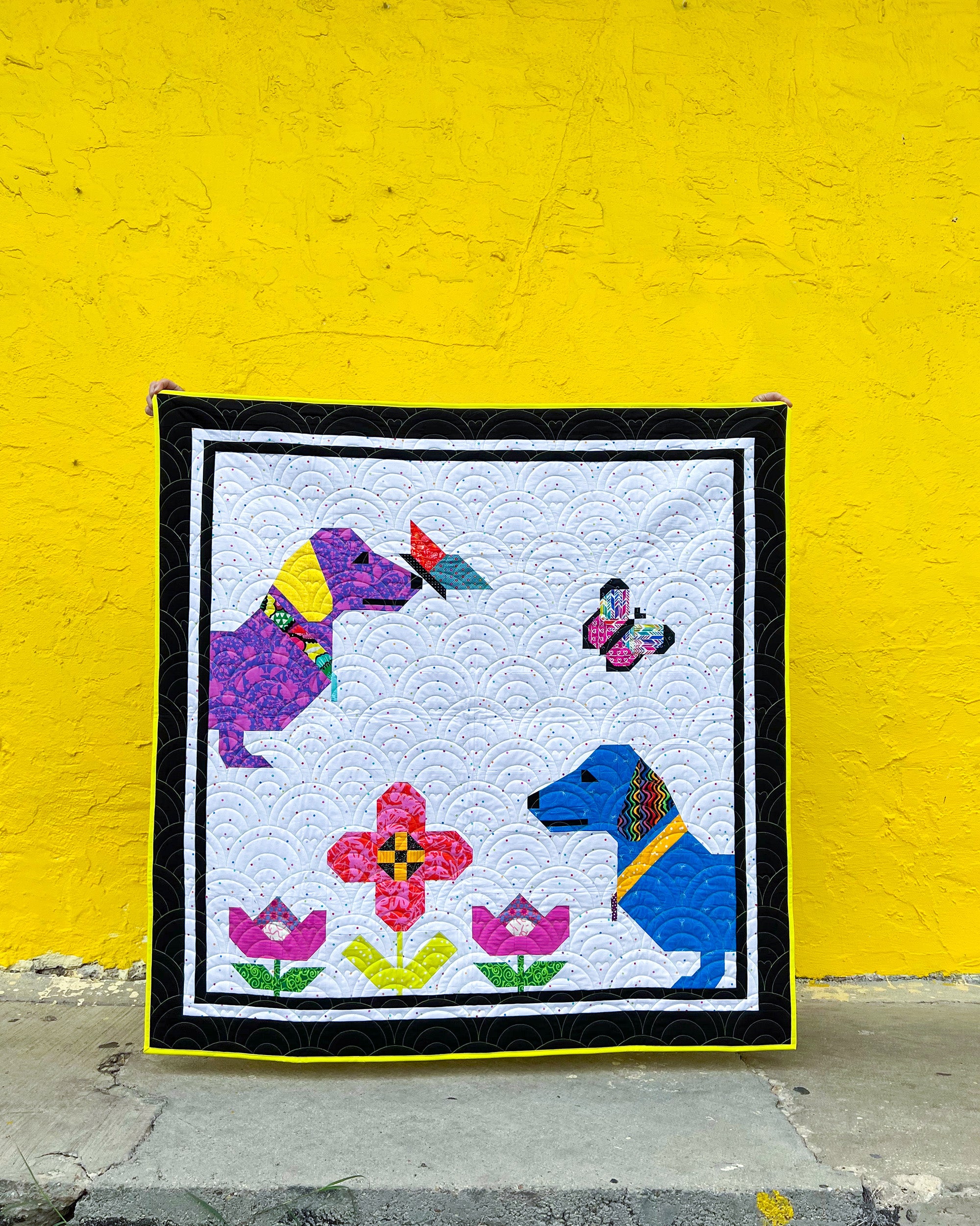 Curious Pups Quilt Scrappy Version against yellow wall