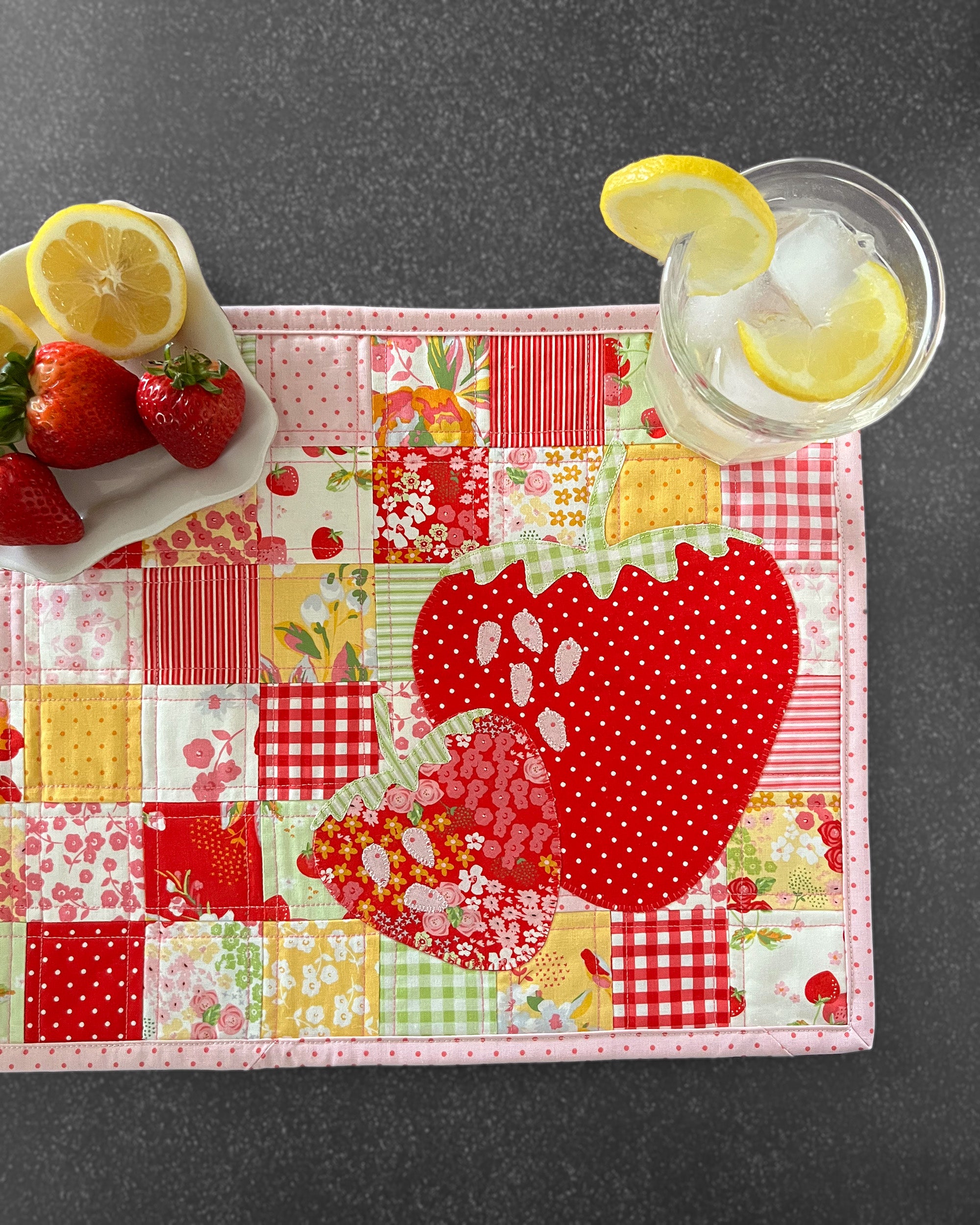 Close up of the Berry Sweet Placemats Pattern with appliqued strawberries