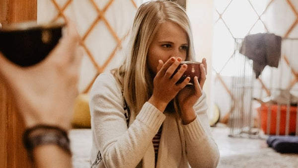 Junge Frau trinkt zeremoniellen Kakao von Moruga in einer tiefen Herzmeditation in Berlin