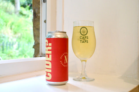 Nightgale Wild Disco cider poured in a Caps and Taps glass on a windowsill. The can is bright red with 'CIDER?' in big vertical lettering. The cider in the glass is a clear pale yellow.