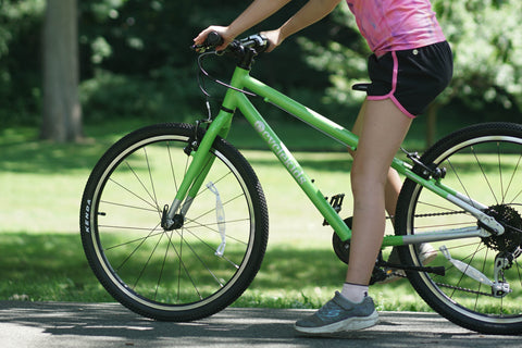 Showing the inseam of a girl on a green bike