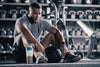 Male athlete recovering from a workout with a protein shake in a drink shaker.
