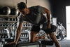 Male athlete on a gym bench lifting a heavy dumbbell