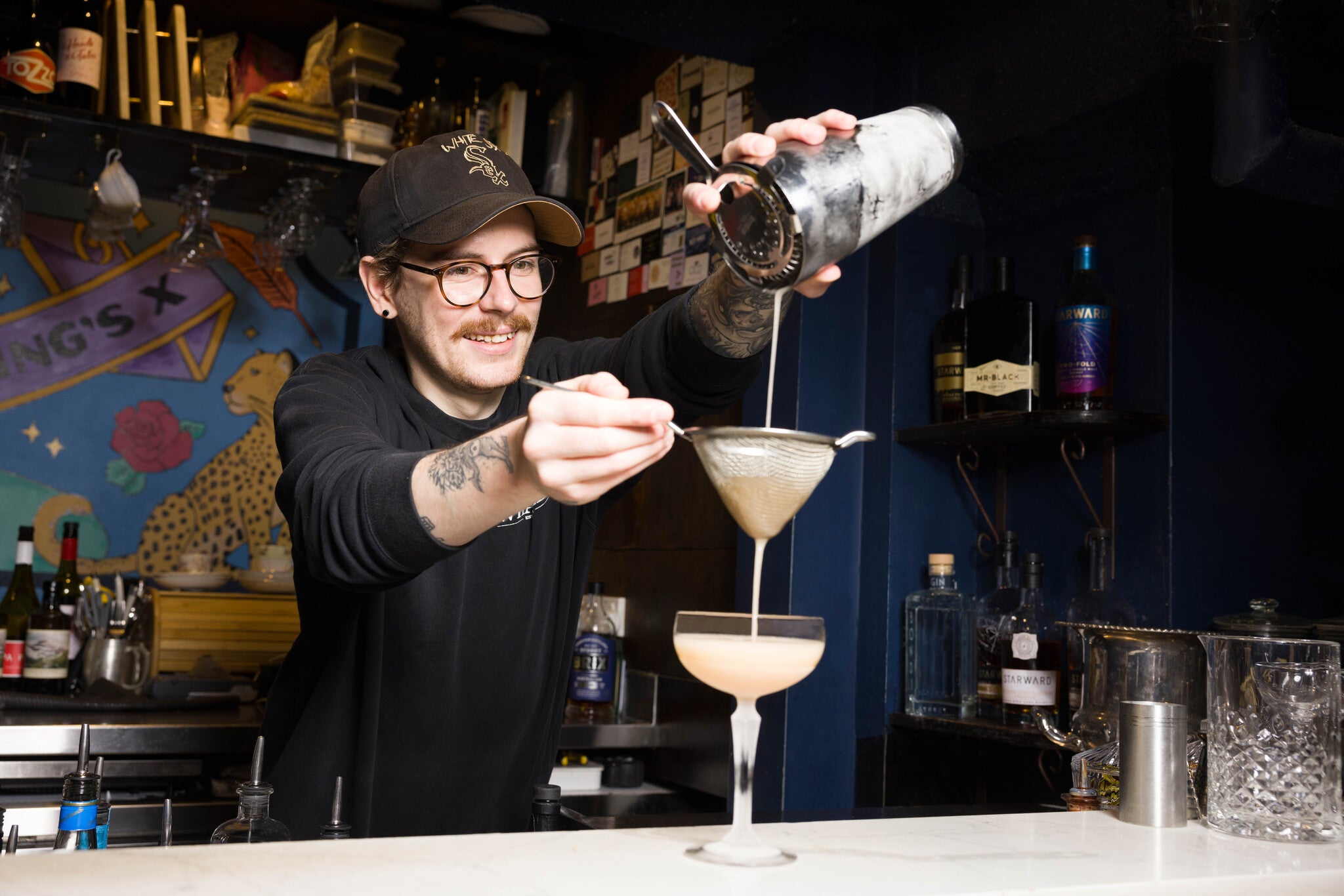 A bartender make a delicious cocktail in a cool bar