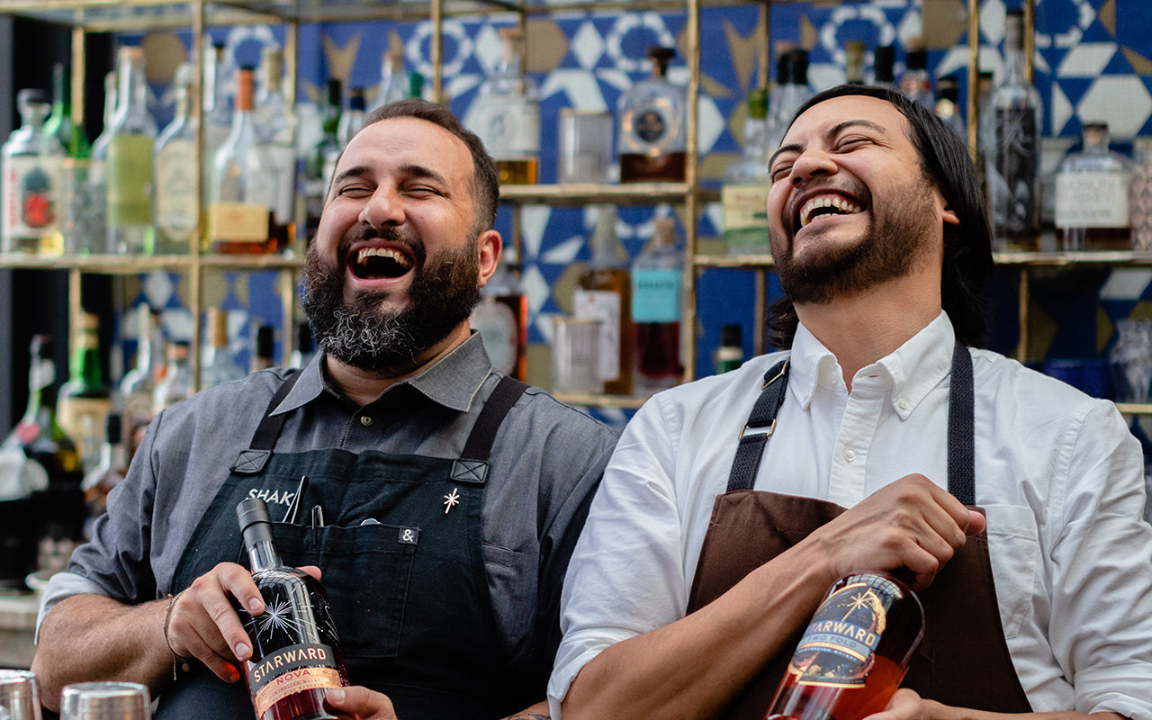 Two guys laughing making cocktails