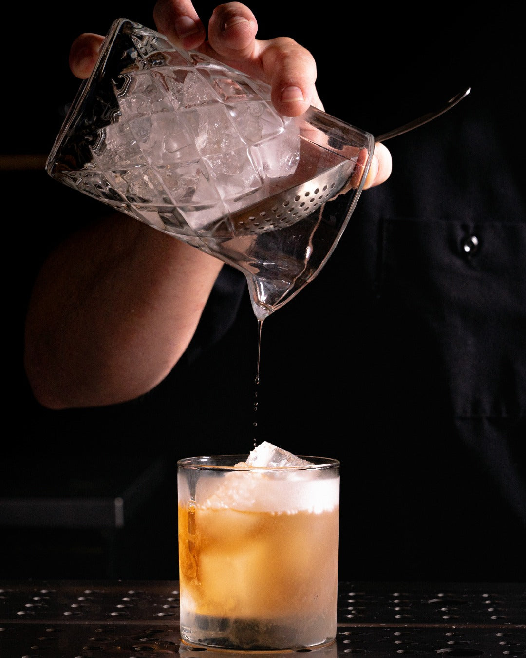 A cinnoman whisky sour being pours out of a stirring glass using Starward whisky