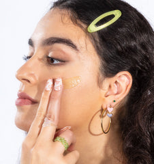 Woman with tan skin tone putting on a tinted sunscreen 