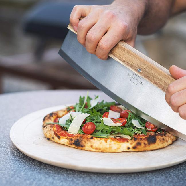 Ein Pizza Wiegemesser schneidet eine Pizza