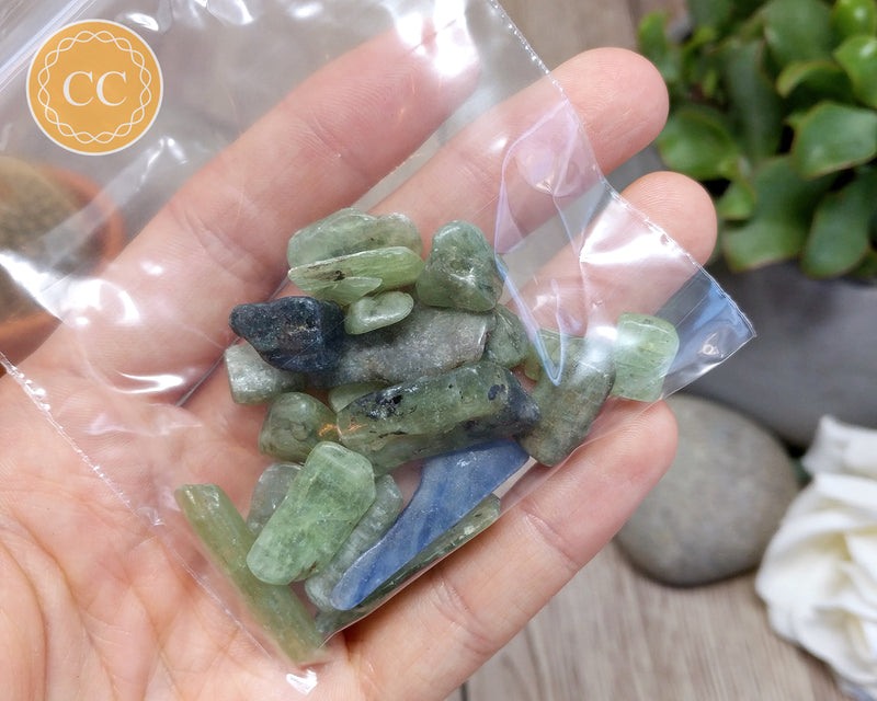 30 grams of Green/Blue Kyanite Crystal Chips in hand in a bag
