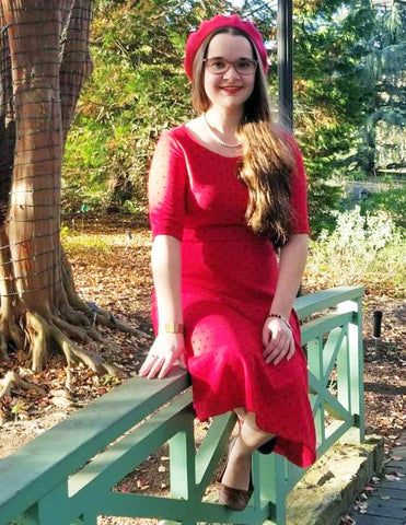 Girl with POTS sitting on a fence in a red dress on a spring day | NormaLyte ORS Electrolyte for POTS