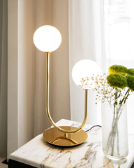 U-shaped gold table lamp with spherical bulbs