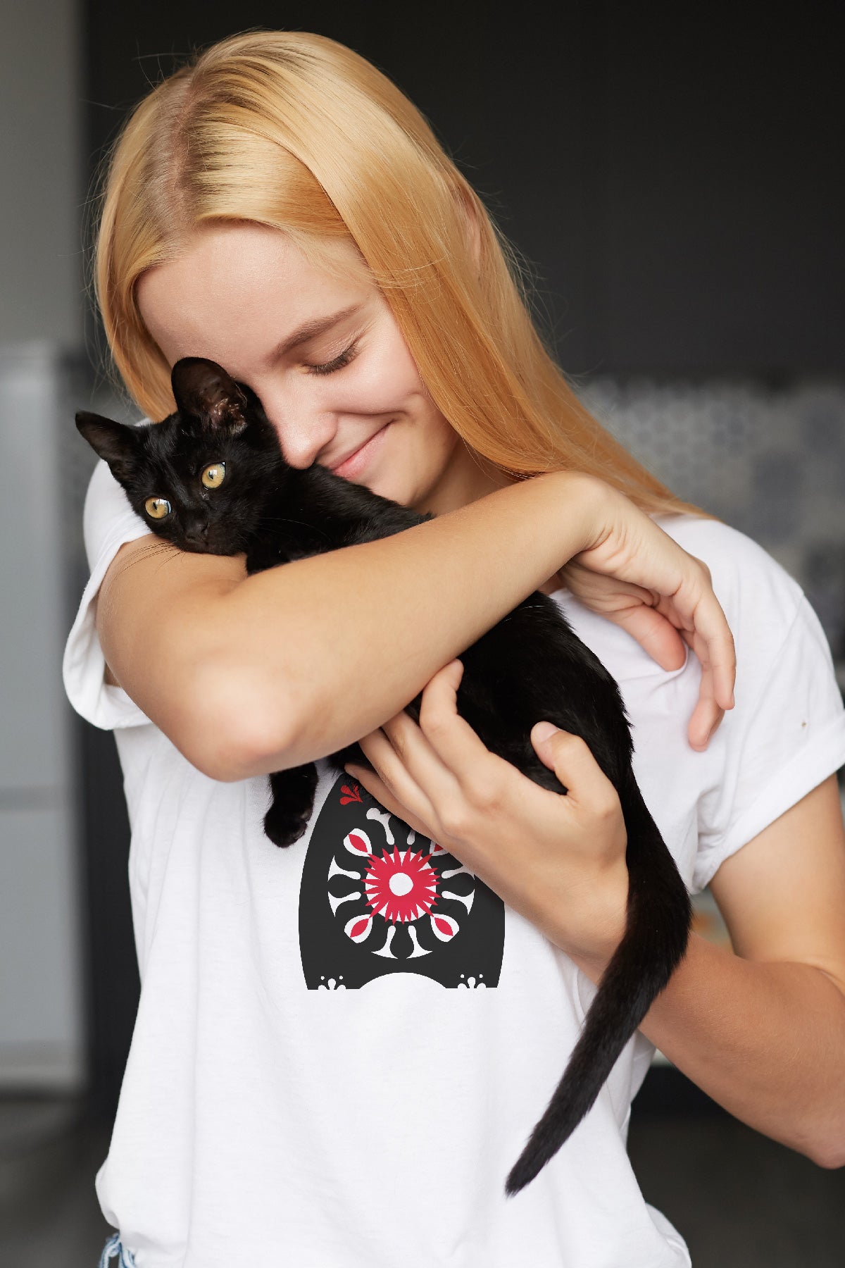 Woman wearing Behemoth t-shirt and holding a black kitten.