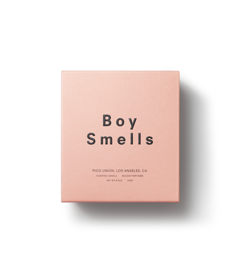 Product shot of front view of exterior candle box in pink with black text and Boy Smells logo.