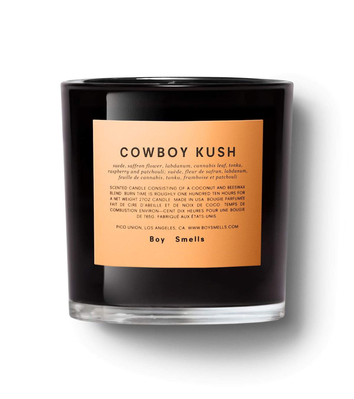 Boy smells black glass candle with orange label reading cowboy kush