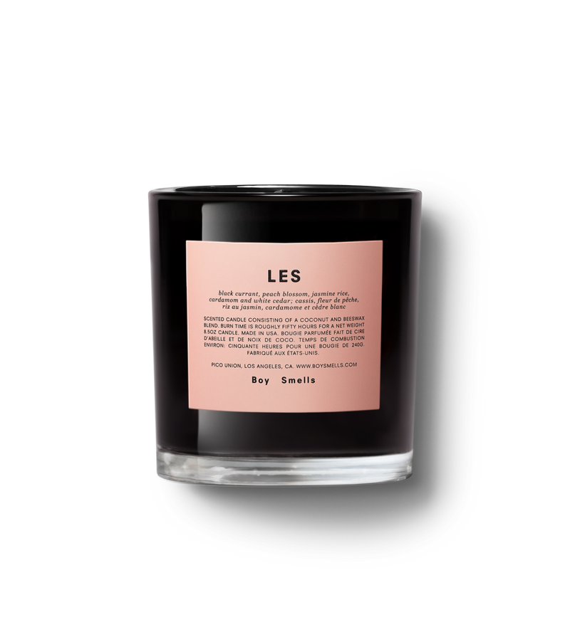 Product shot of front view Les in black glossy vessel with pink label against neutral background.