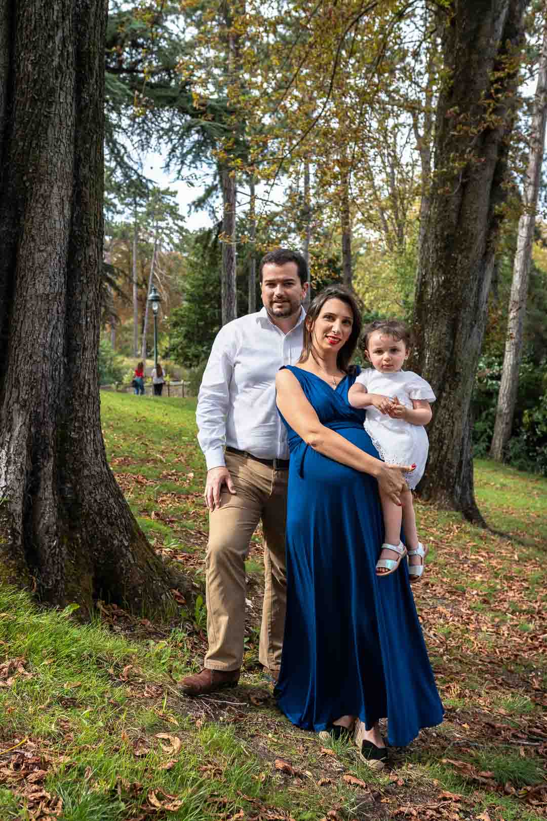 Couple avec leur enfant lors d'un shooting grossesse au parc Montsouris