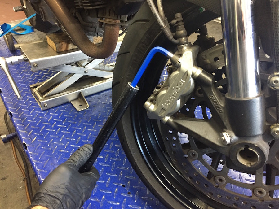 person Changing motorcycle brake pads