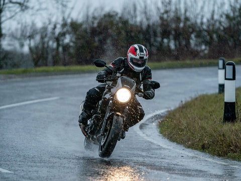 motorcycle going around a corner in the rain