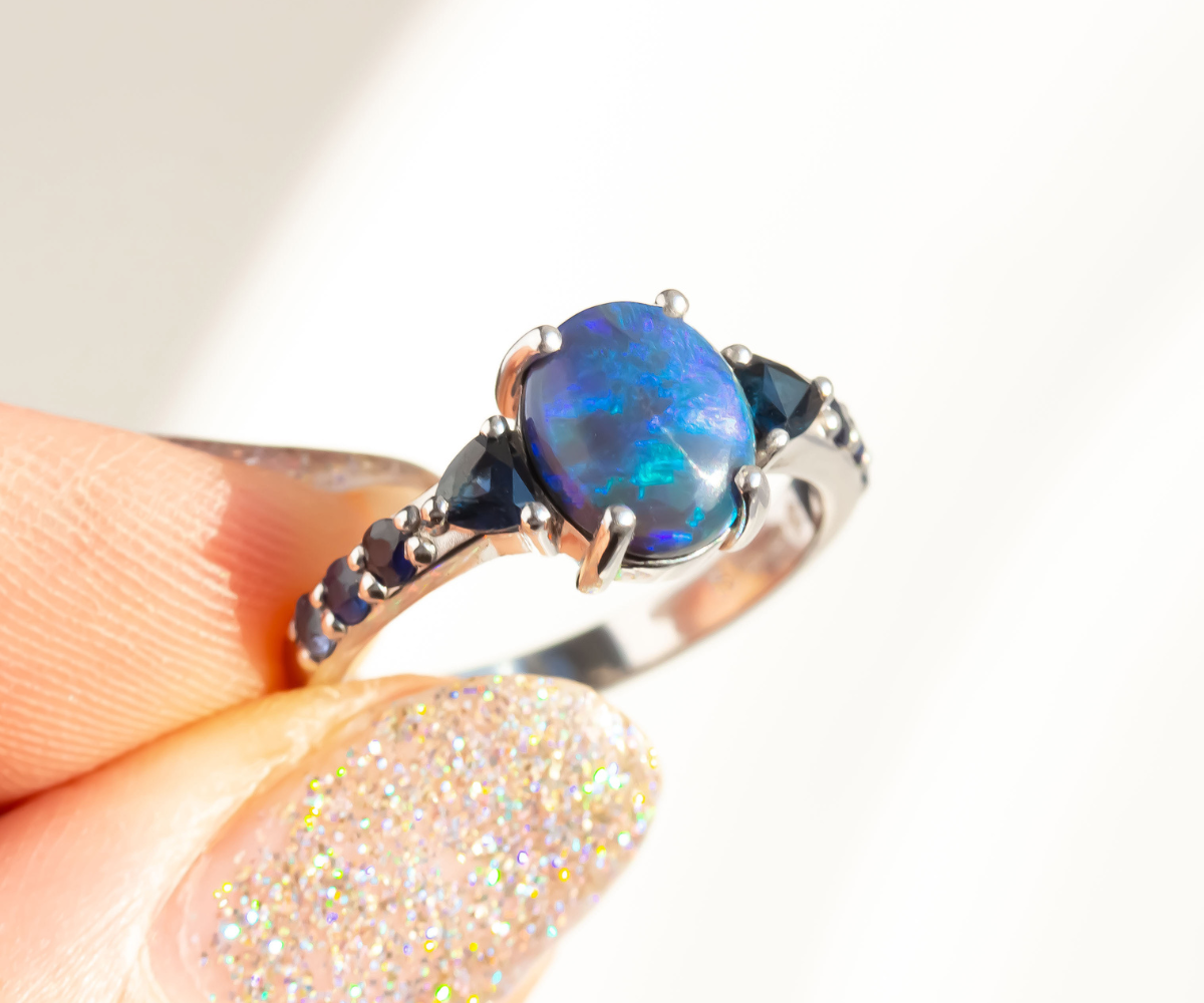 black opal ring with ombre blue sapphires set into the band in white gold