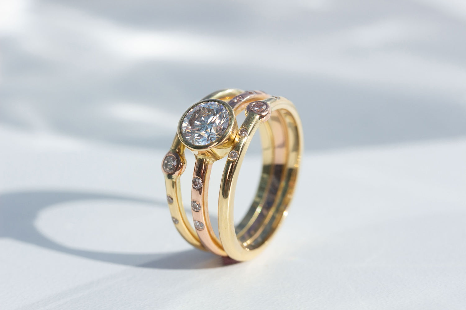Triple Ring Design in 18K Yellow and Rose Gold and 1ct Diamond Ring Remodel on white background