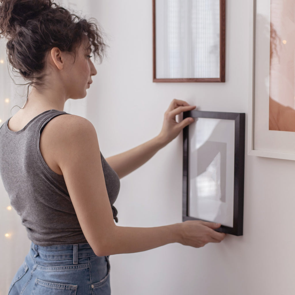 woman styling frames on the walls